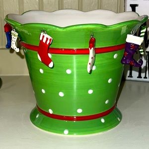 Whimsical green ceramic pot planter with hanging Christmas stockings.